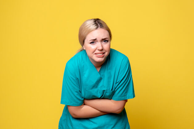成人黄墙上年轻女医生穿着医用衬衫胃痛的正面图快乐人护士