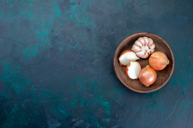 配料顶视图洋葱和大蒜在深蓝色碗食物深色