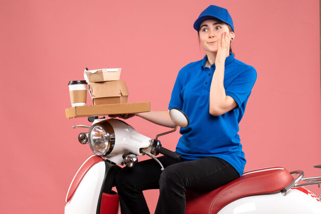 人正面图女快递员带着食品包和盒子上粉红色的送货自行车上班族制服服务颜色前面自行车送货