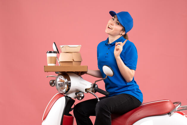 工作正面图：女快递员带着食品包装盒和粉色工作服上的彩色工人送食品制服服务景观制服箱子