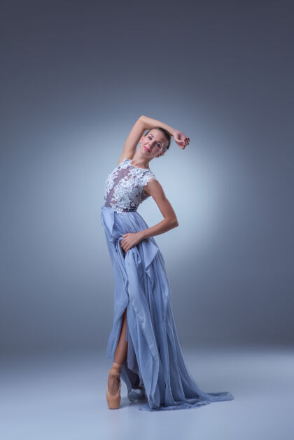 芭蕾舞演员美丽的芭蕾舞演员在蓝色背景上穿着蓝色长裙跳舞芭蕾舞运动人