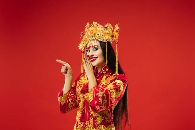 美丽中国传统的优雅女子在红色背景的工作室里传统亚洲模特
