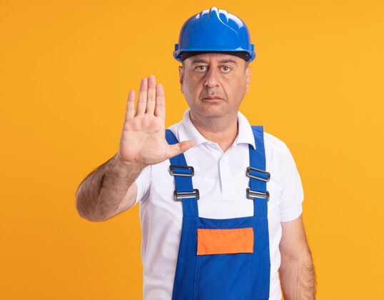 人自信的白人成年建筑工人在制服手势停止手上的橙色标志手信心人