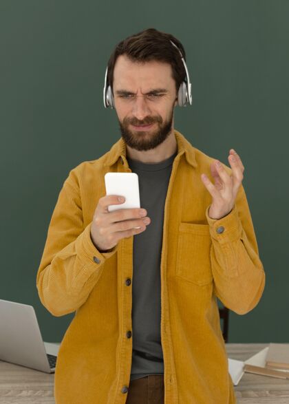 笔记本电脑带耳机的肖像男用手机排毒科技排毒