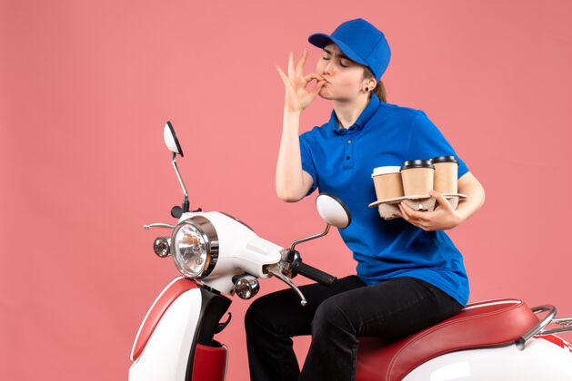 人正面图女快递员骑在自行车上拿着咖啡杯上粉色工作服颜色制服送货员餐饮服务前面景观咖啡