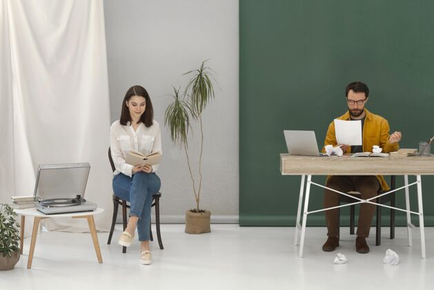 男性女人一边看书一边放松 男人一边用笔记本电脑设备科技工作