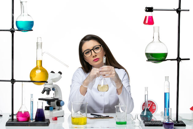 人前视图穿着白色医疗服的女化学家拿着白色背景上的溶液-科学大流行实验室病毒医学科学大流行