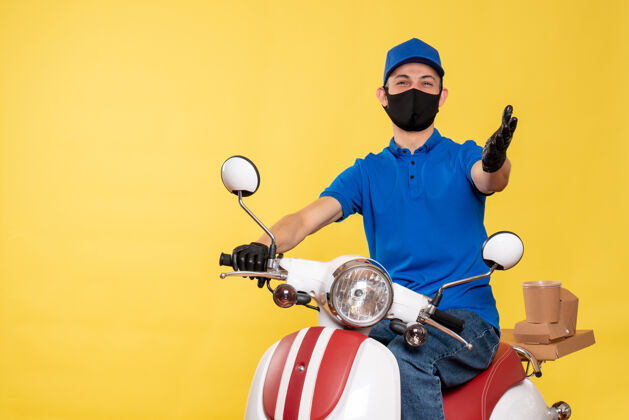 送货正面图：男快递员穿着蓝色制服 戴着黄色口罩 工作着病毒冠状病毒 送货大流行 自行车服务工作运动视图面罩