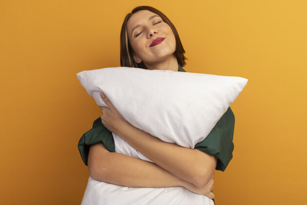 黑发可爱的白种女人抱着桔子枕头枕头拜托年轻