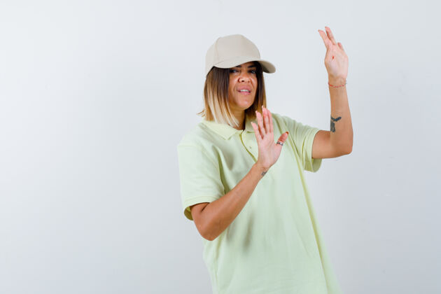 亚洲穿着t恤 戴着帽子的年轻女性展示着投降的手势 看起来很无助前视图模型显示护理