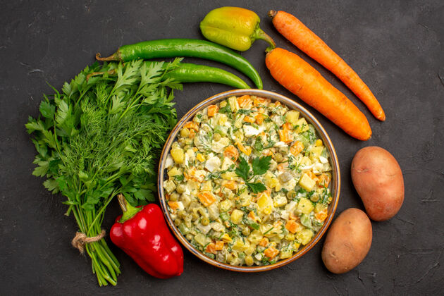 新鲜在黑暗的背景下 俯瞰美味的沙拉和绿色和新鲜蔬菜健康深色胡椒
