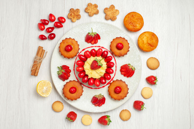 甜点俯瞰白色桌子上盘子里的水果蛋糕饼干花糖果