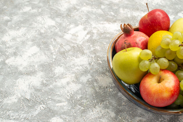 观正面视图新鲜水果组成苹果葡萄等水果的白色背景新鲜醇厚的水果成熟的颜色维生素V前葡萄生