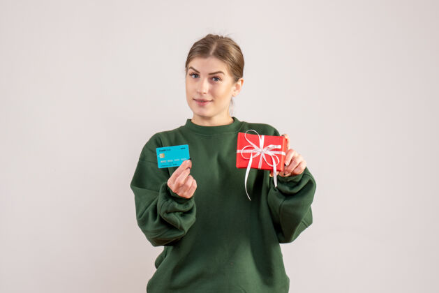 圣诞节前视图年轻女性 带着小圣诞礼物和银行卡礼物节日孩子