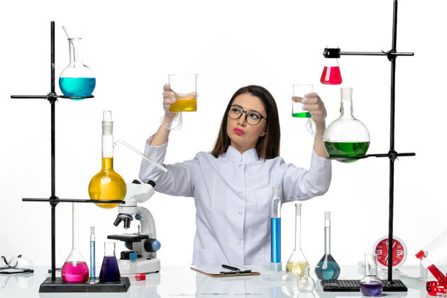 医学前视图穿着白色医疗服的女化学家拿着装有白色背景实验室科学病毒柯维大流行解决方案的烧瓶烧瓶工作解决方案