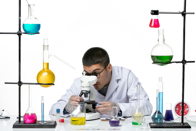 套装前视图男性化学家穿着白色医疗服 在白色背景上用显微镜观察病毒实验室冠状病毒-疾病科学视图科学罐子