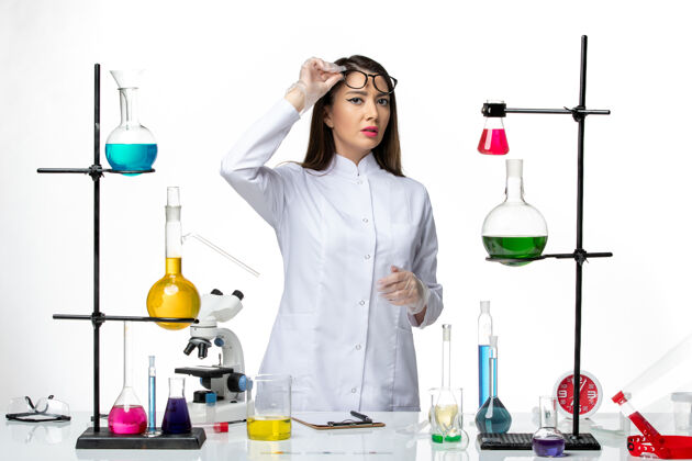 病毒前视图：穿着无菌医疗服的女化学家正在处理白色背景实验室病毒冠状病毒-大流行科学成人视图实验室
