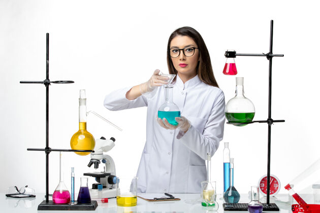 科学正面图：穿着无菌医疗服的女化学家在白色背景病毒冠状病毒上用不同的溶液工作-大流行科学解决方案人医生