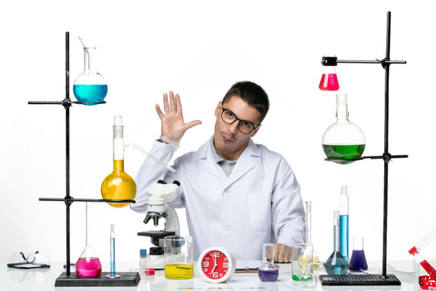 科学正面图身穿白色医疗服的男性化学家在白色背景上向某人挥手病毒科学冠状病毒-大流行实验室病毒实验室医学