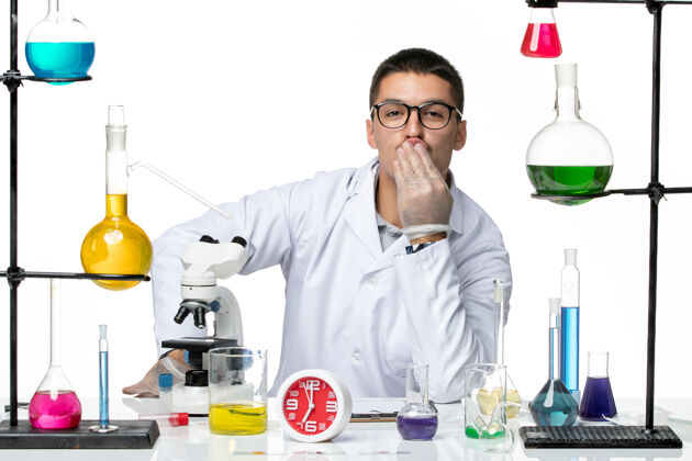 大流行前视图穿着白色医疗服的男性化学家坐在一个白色背景的实验室病毒科学冠状病毒大流行的解决方案视图实验室实验室