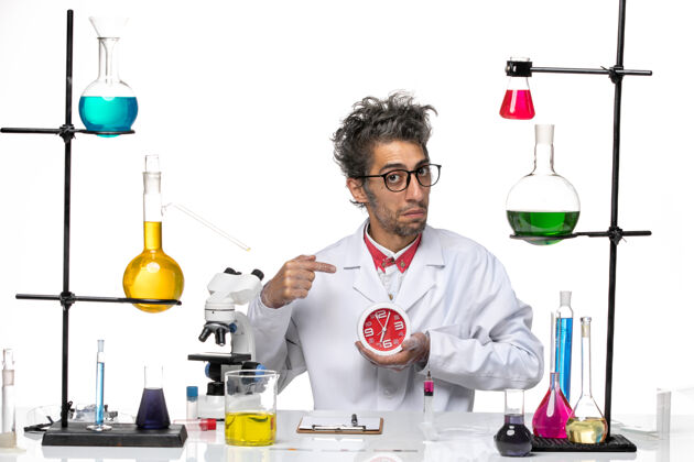 人正面图身穿医疗服的男科学家在白色办公桌上拿着时钟化学冠状病毒-实验室病毒健康医生职业桌