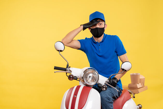 高尔夫正面图男性快递员戴着黄色工作服戴着面罩坐在自行车上-制服递送人摩托车工作