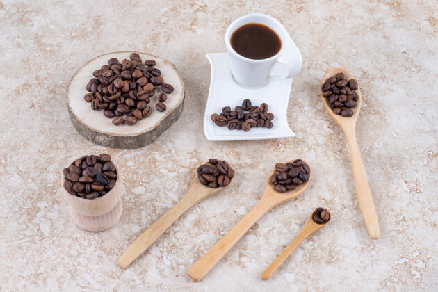 豆子一杯咖啡旁边放着几小捆咖啡豆咖啡芳香