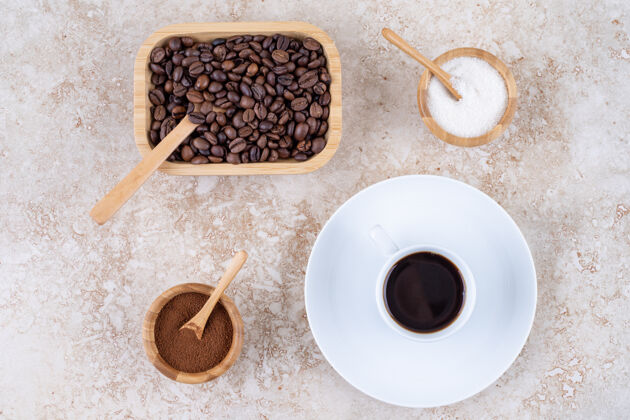 咖啡豆一小碗糖旁边的各种形式的咖啡茶碟杯子