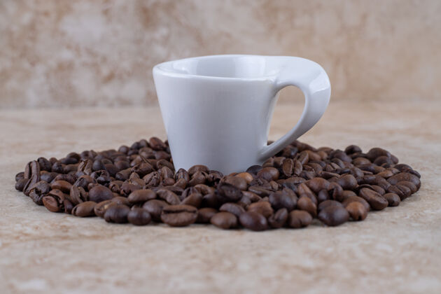 堆积整齐排列的咖啡豆堆围绕着一杯咖啡咖啡排列