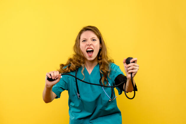 医学女医生在浅黄色墙壁上测量压力的正视图女人女士制服