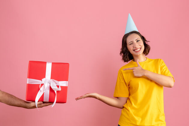 礼物正面图：年轻的女性在接受来自男性的粉色礼物快乐圣诞节女人