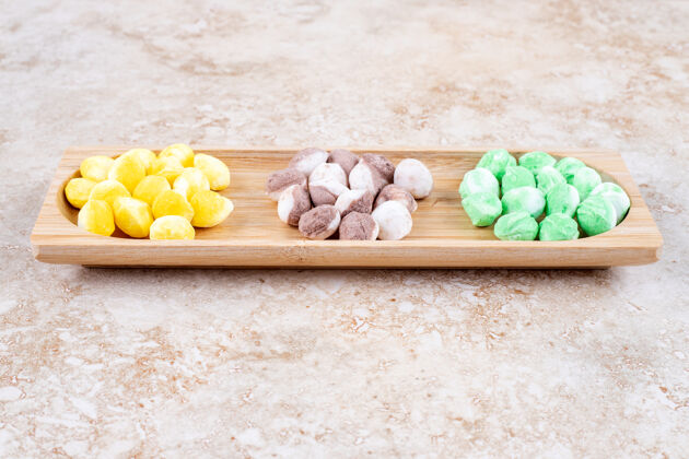 小吃各种各样的糖果捆在一个小木托盘里糖果美味美味