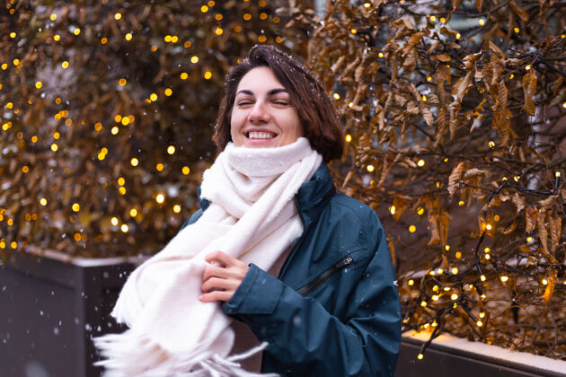 城市高加索快乐微笑的女人享受着雪和冬天 戴着温暖的围巾情感肖像微笑