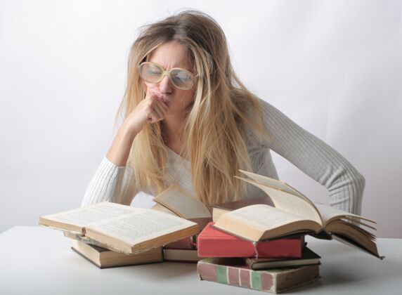 纸张一个头发凌乱的女人在她面前读几本书的特写镜头知识焦虑乱糟糟