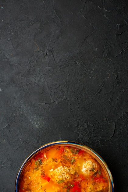 容器在深灰色空间俯瞰美味的肉汤和熟土豆和肉生的土豆美味
