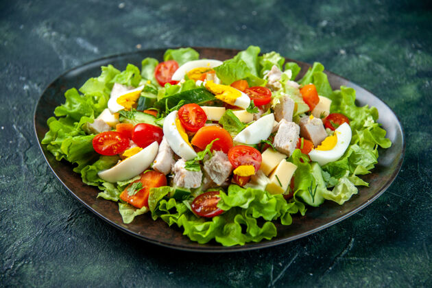 饮食自制美味沙拉的俯视图 在黑绿色混合色的背景下 盘子里有许多配料混合配料晚餐