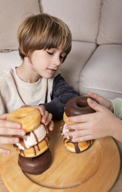可爱孩子们在家吃甜甜圈年轻快餐营养