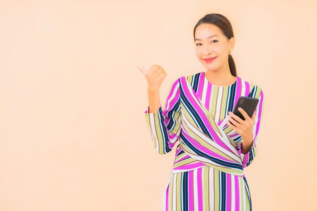 电话肖像美丽的亚洲年轻女子用智能手机上色手机年轻信息