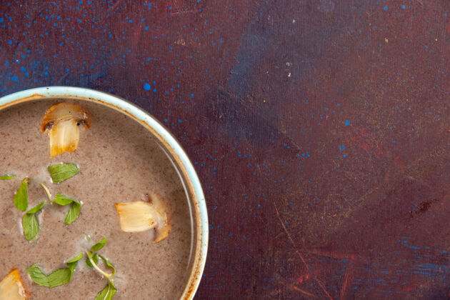 生的在深紫色桌子上的盘子里俯瞰美味的蘑菇汤顶容器热的