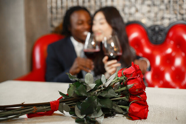 非裔美国人女孩手指上的结婚戒指一束红玫瑰订婚礼物浪漫花束束