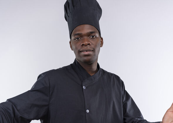 烹饪身着厨师制服的年轻美籍黑人厨师假装将相机隔离在白色背景上 并留有复印空间年轻请拿着