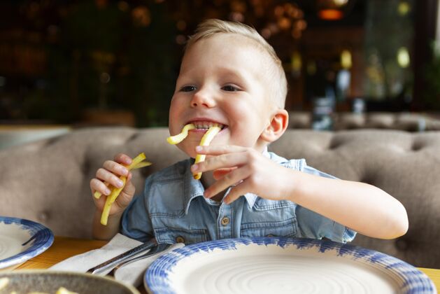 中镜头快乐的孩子吃薯条烹饪美食水平