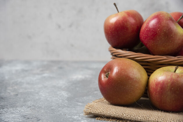 营养柳条篮成熟闪亮的苹果在大理石表面衣服自然水果