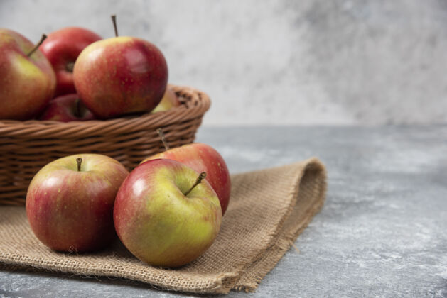 花园柳条篮成熟闪亮的苹果在大理石表面美味苹果水果