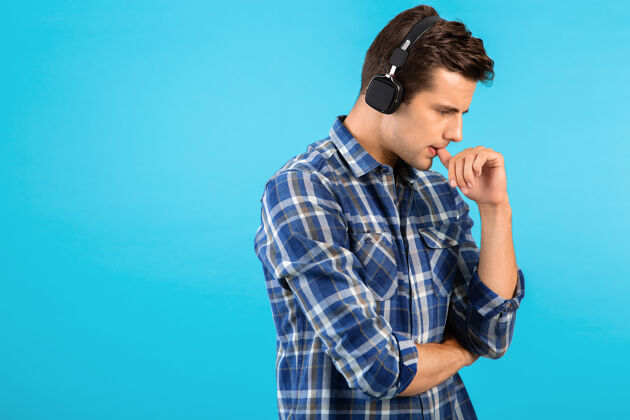 耳机时尚帅气的年轻人戴着无线耳机听音乐立体声扬声器家伙