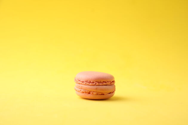 美味黄色背景上粉红色杏仁饼的特写镜头甜点粉彩黄色
