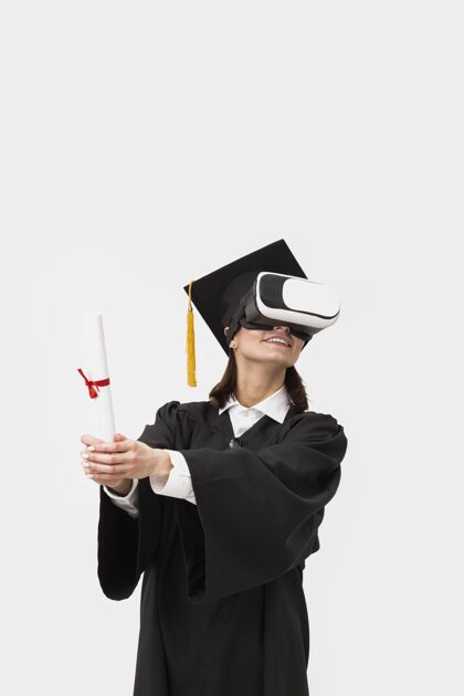 虚拟现实眼镜穿着毕业礼服戴毕业帽戴着虚拟现实耳机的女人技术毕业设备