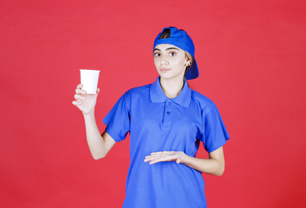 员工穿着蓝色制服的女服务人员手里拿着一杯一次性饮料年轻人服装人类