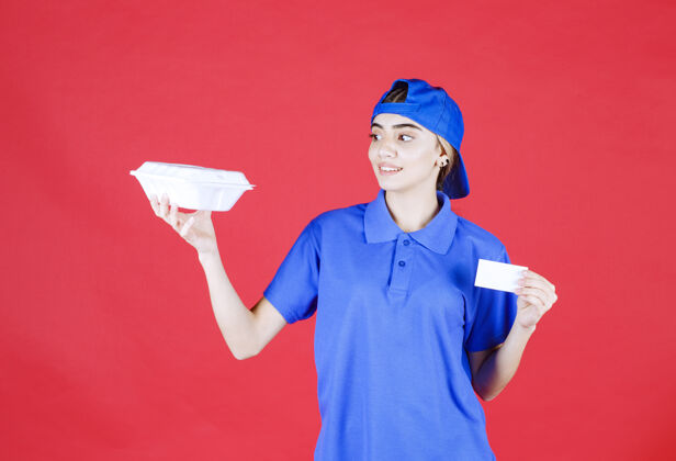 电子邮件穿着蓝色制服的女快递员拿着一个白色的外卖盒 出示她的名片智能服务网络
