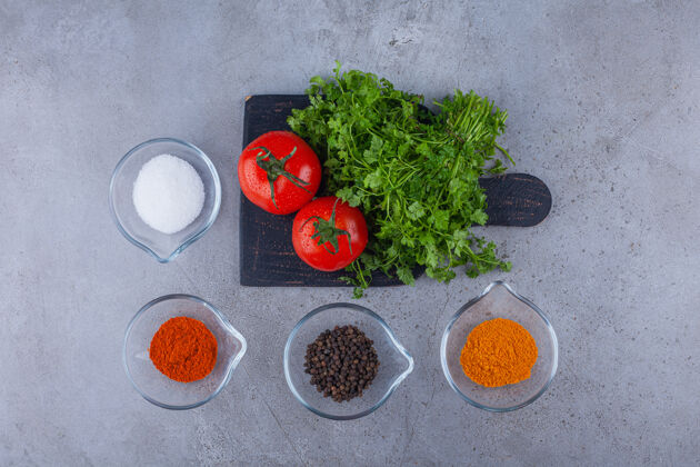 蔬菜新鲜的西红柿和欧芹叶放在黑色的砧板上 配上调味品欧芹健康成熟的